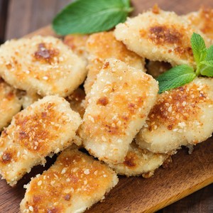 Sesame chicken nuggets on a rustic wooden cutting board