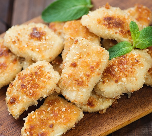 Sesame chicken nuggets on a rustic wooden cutting board